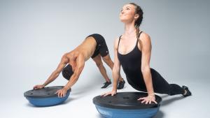 man and woman stretching with a bosu