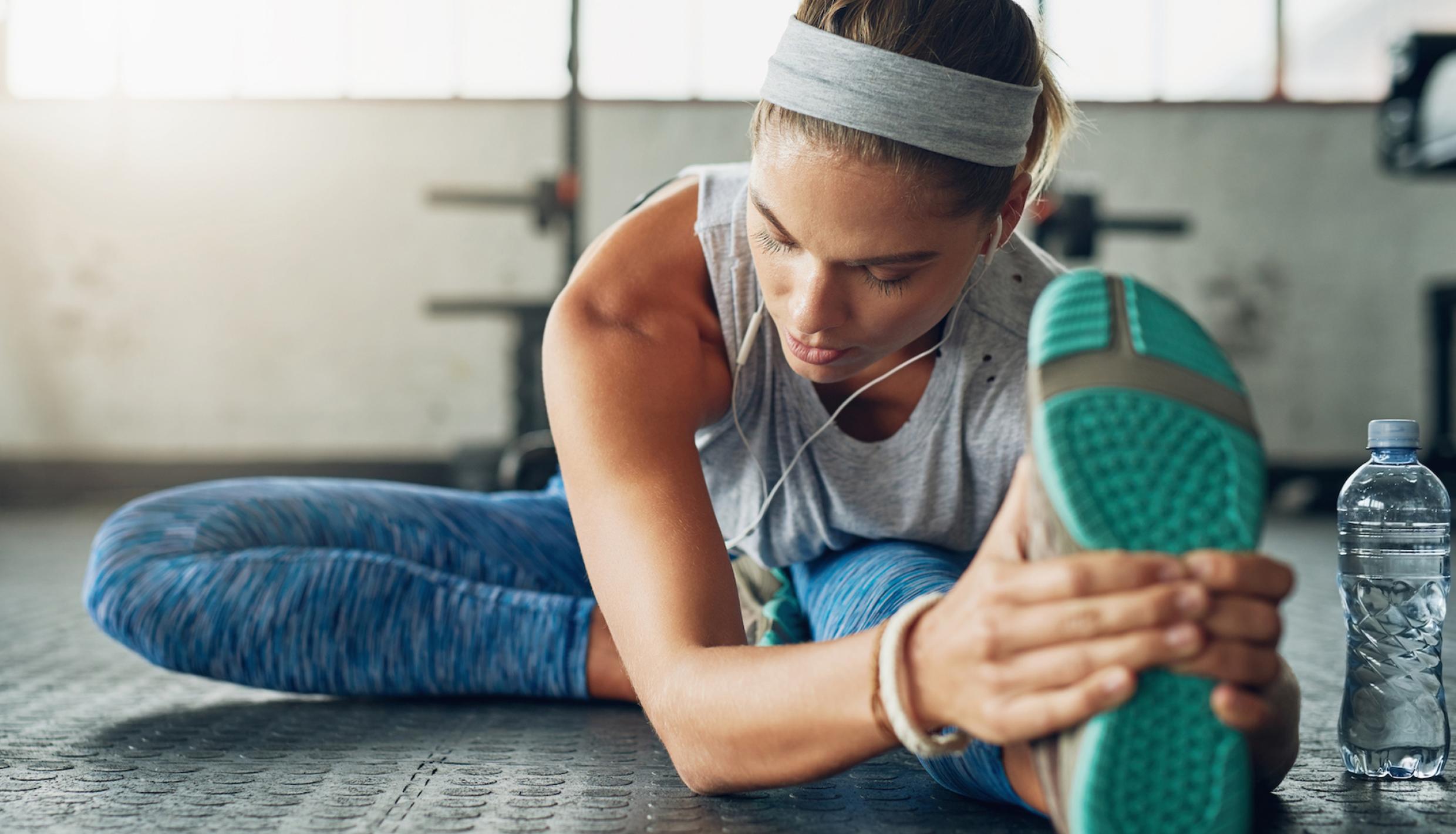 Una mujer se estira mientras se prepara para entrenar