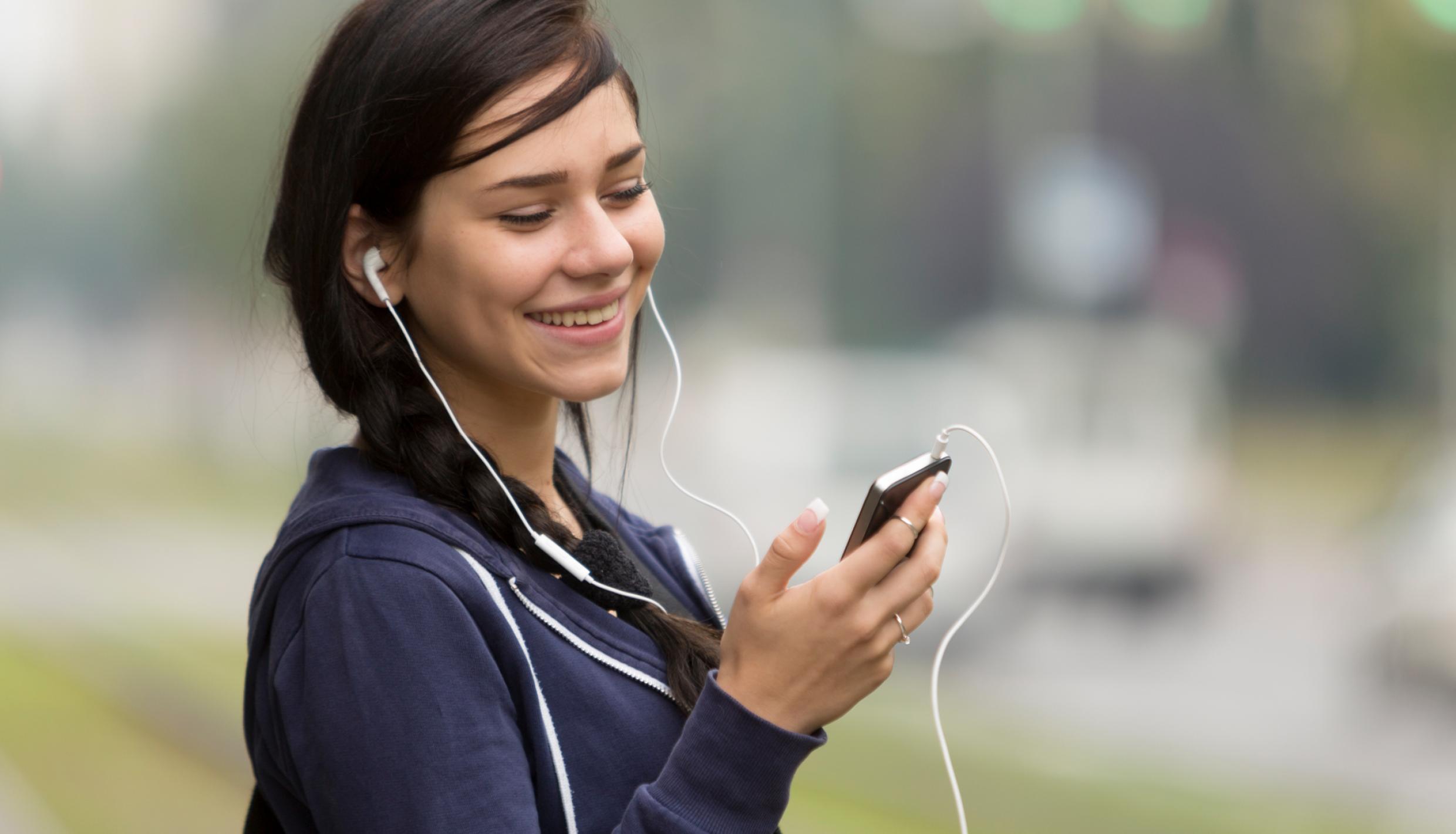 Woman listening to music through ear buds
