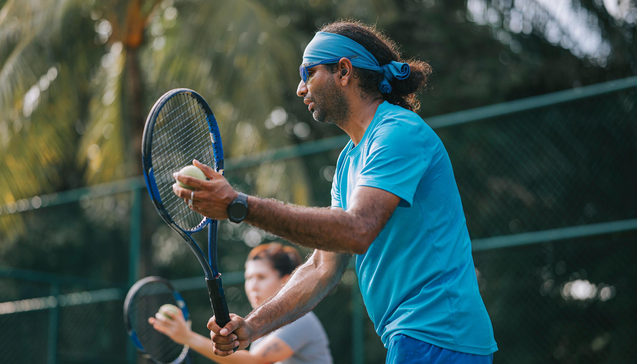 man playing tennis wearing a hearing aid
