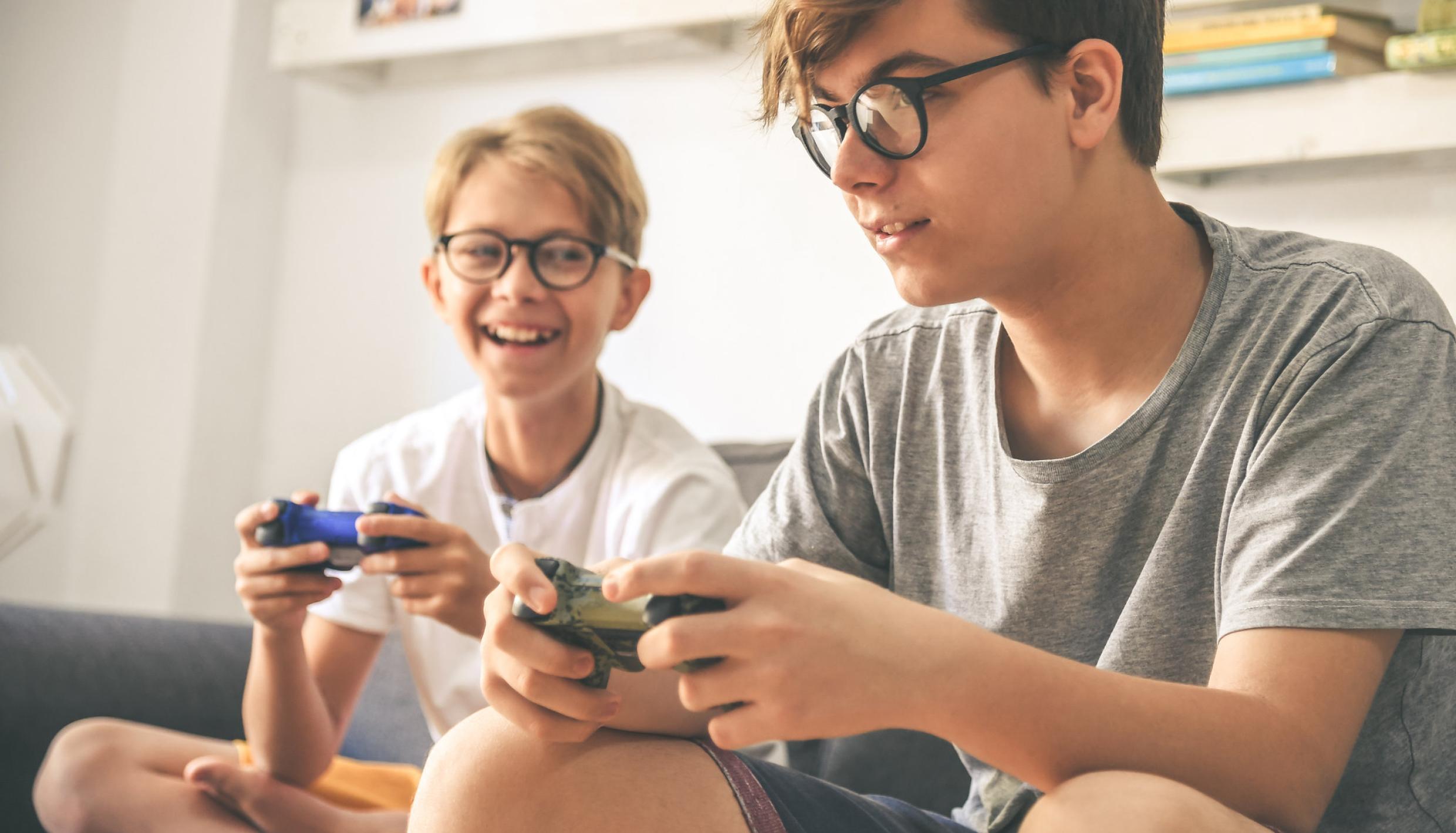 niños con espejuelos jugando video juegos