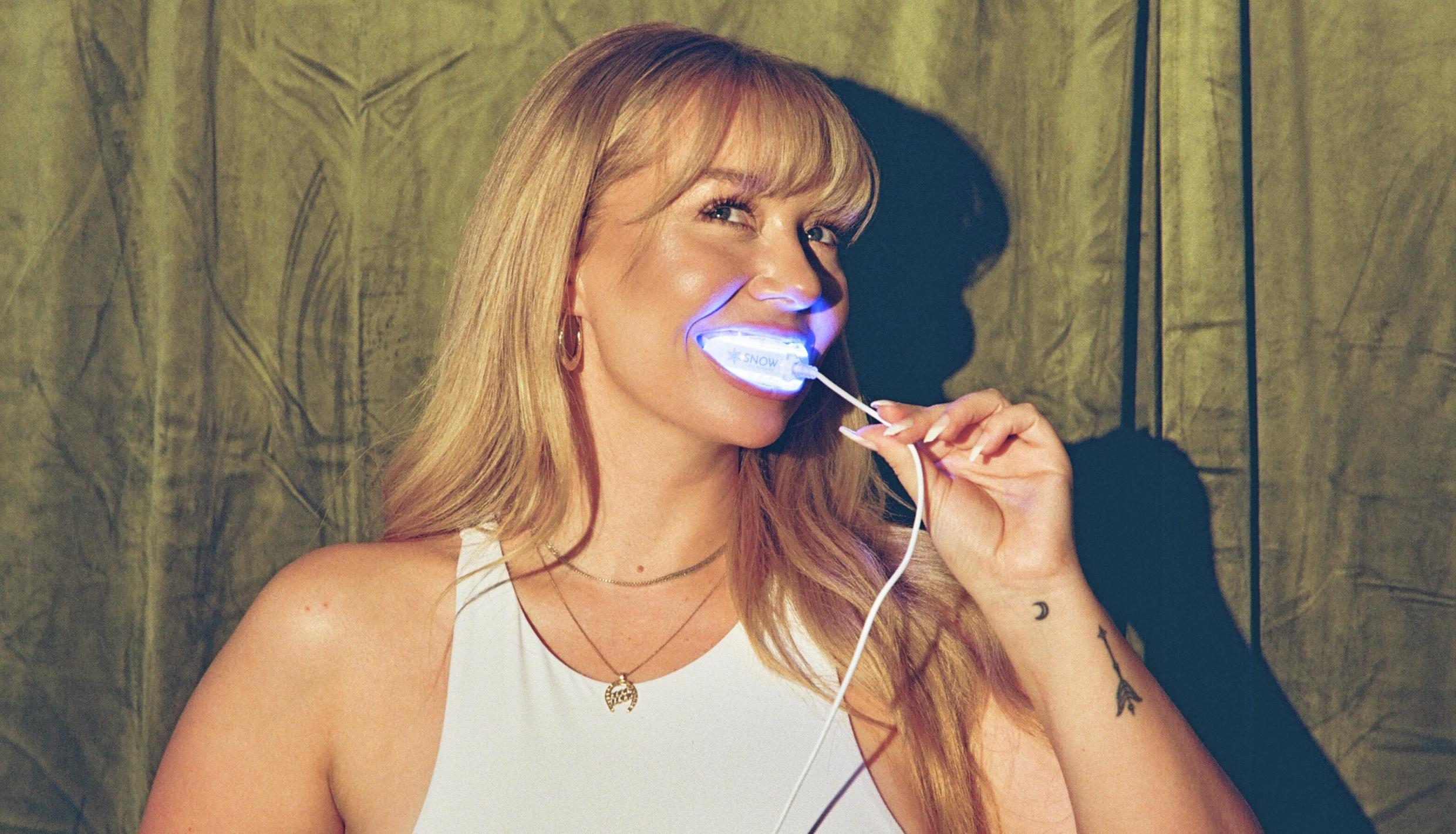 Woman whitening her teeth