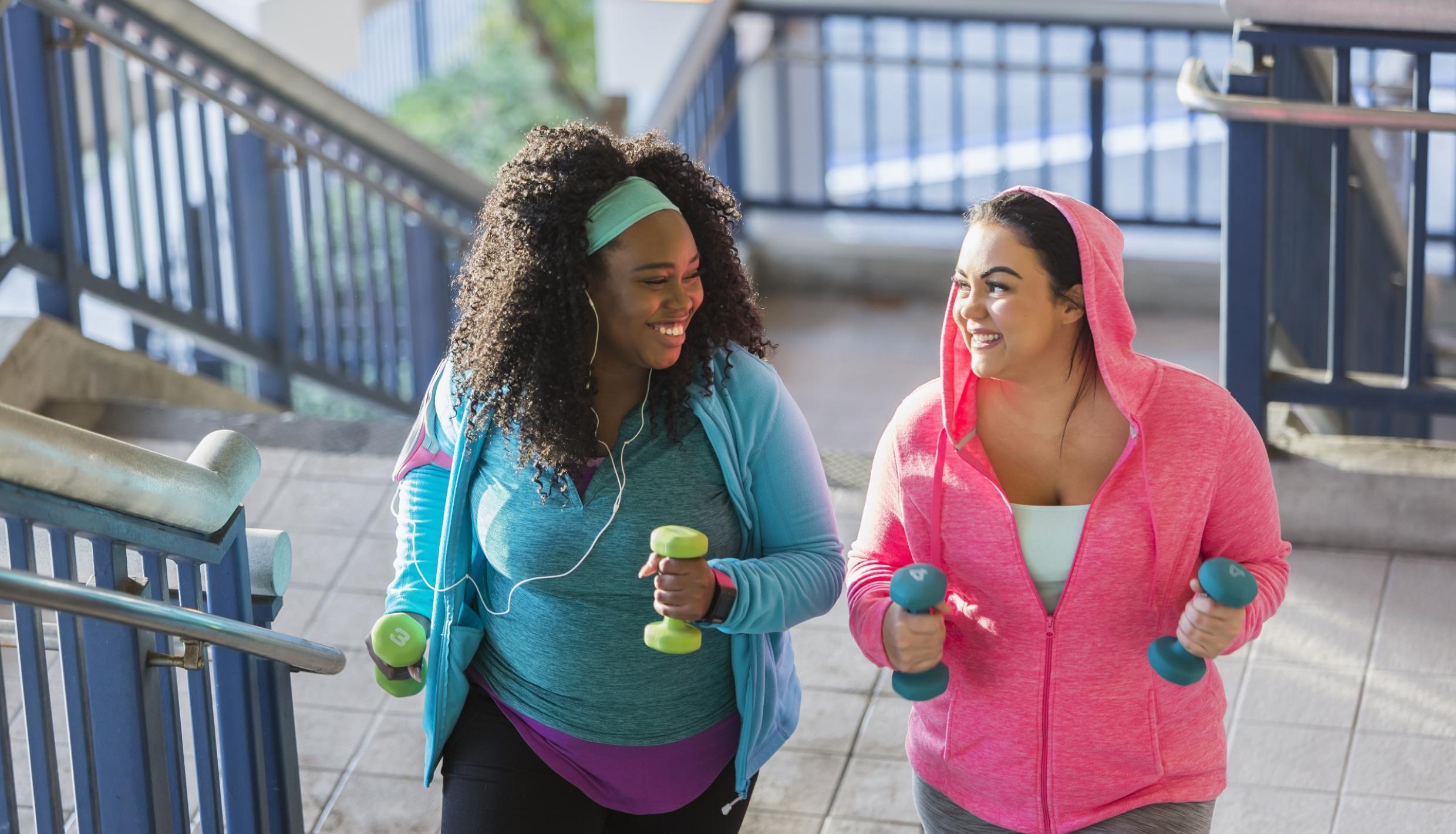 women walking holding dumbells