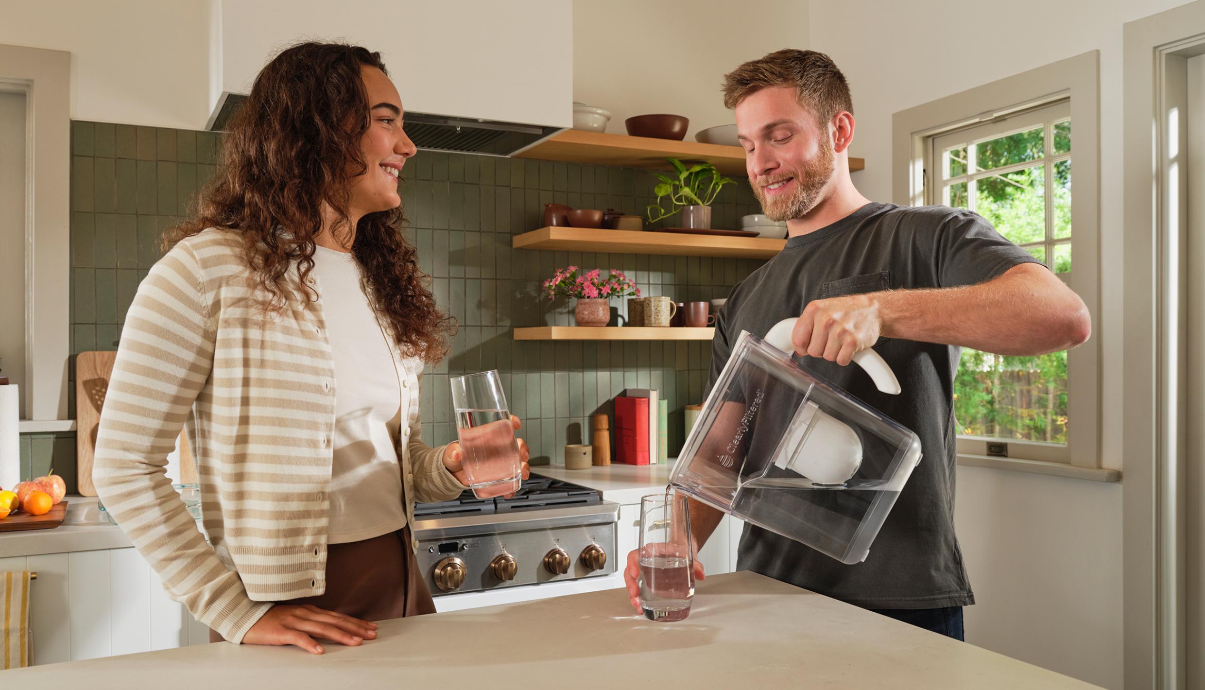 Man and woman pouring water into a glass