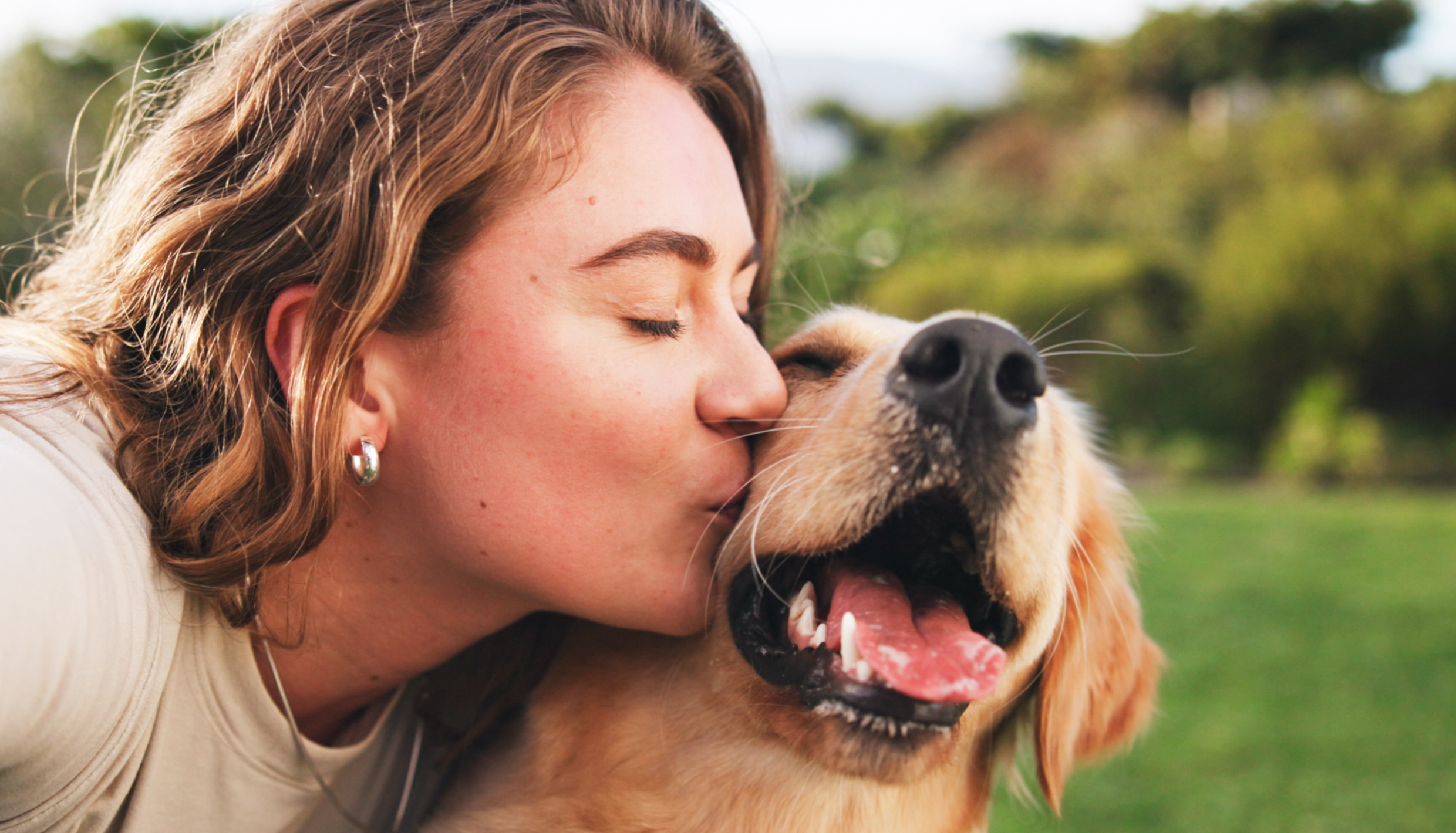 Woman kissing dog