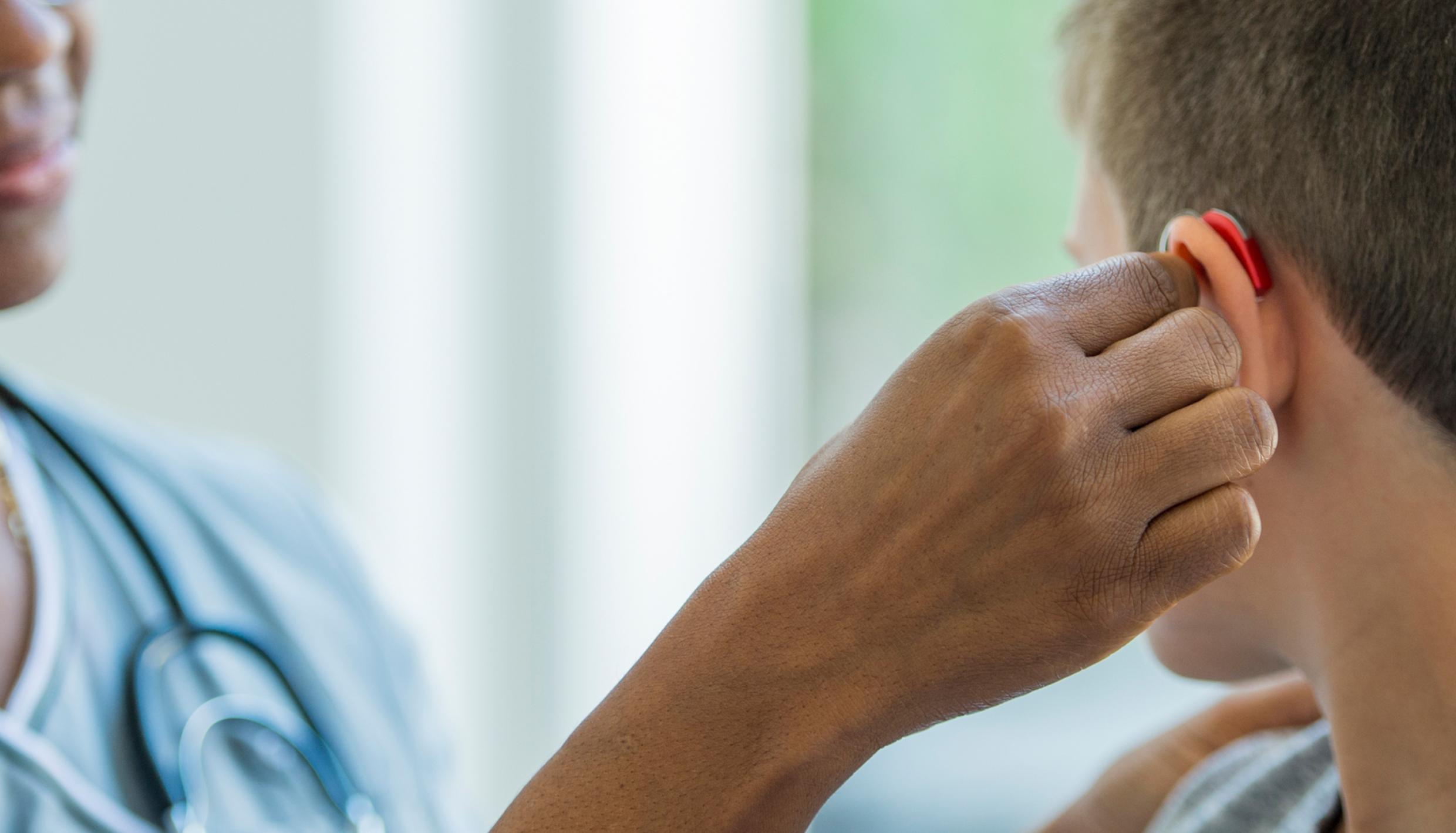 Woman trying out hearing aids with young man