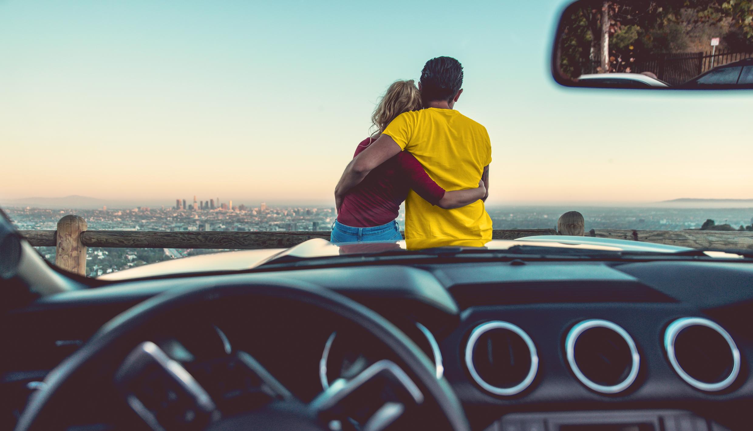 Man and woman on hood of car
