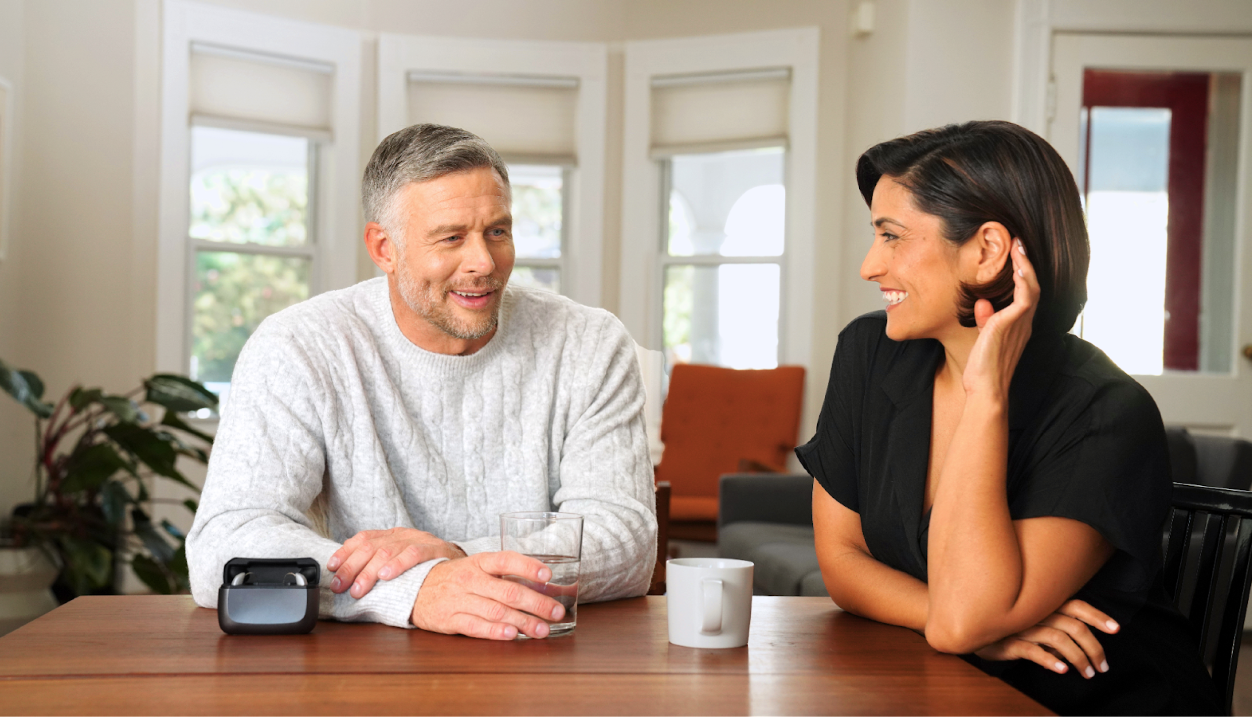 Two people talking at table.