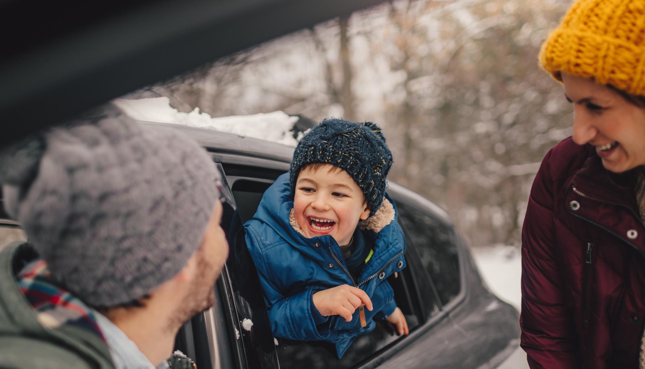Family of three getting into car for a trip