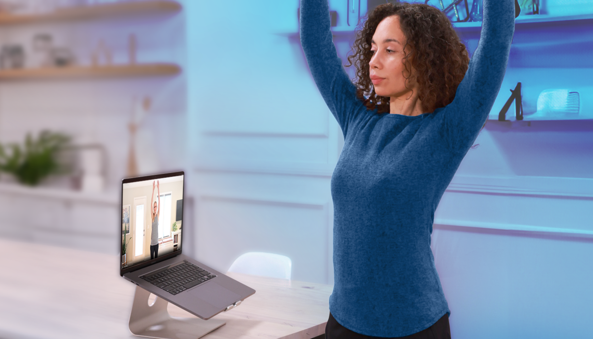 woman stretching while watching laptop