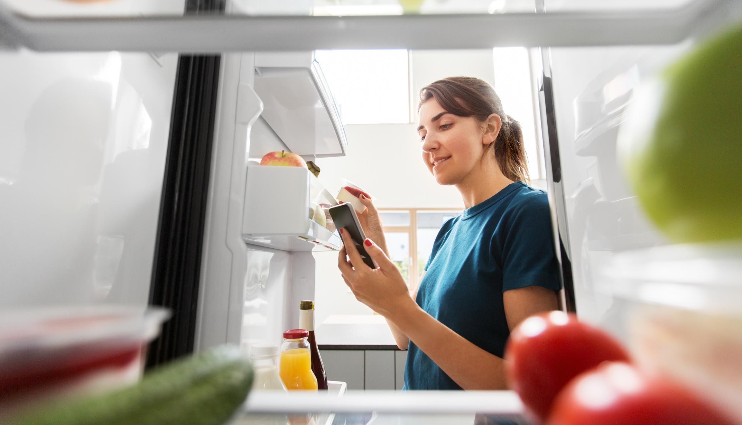 Mujer mirando dentro del refrigerador