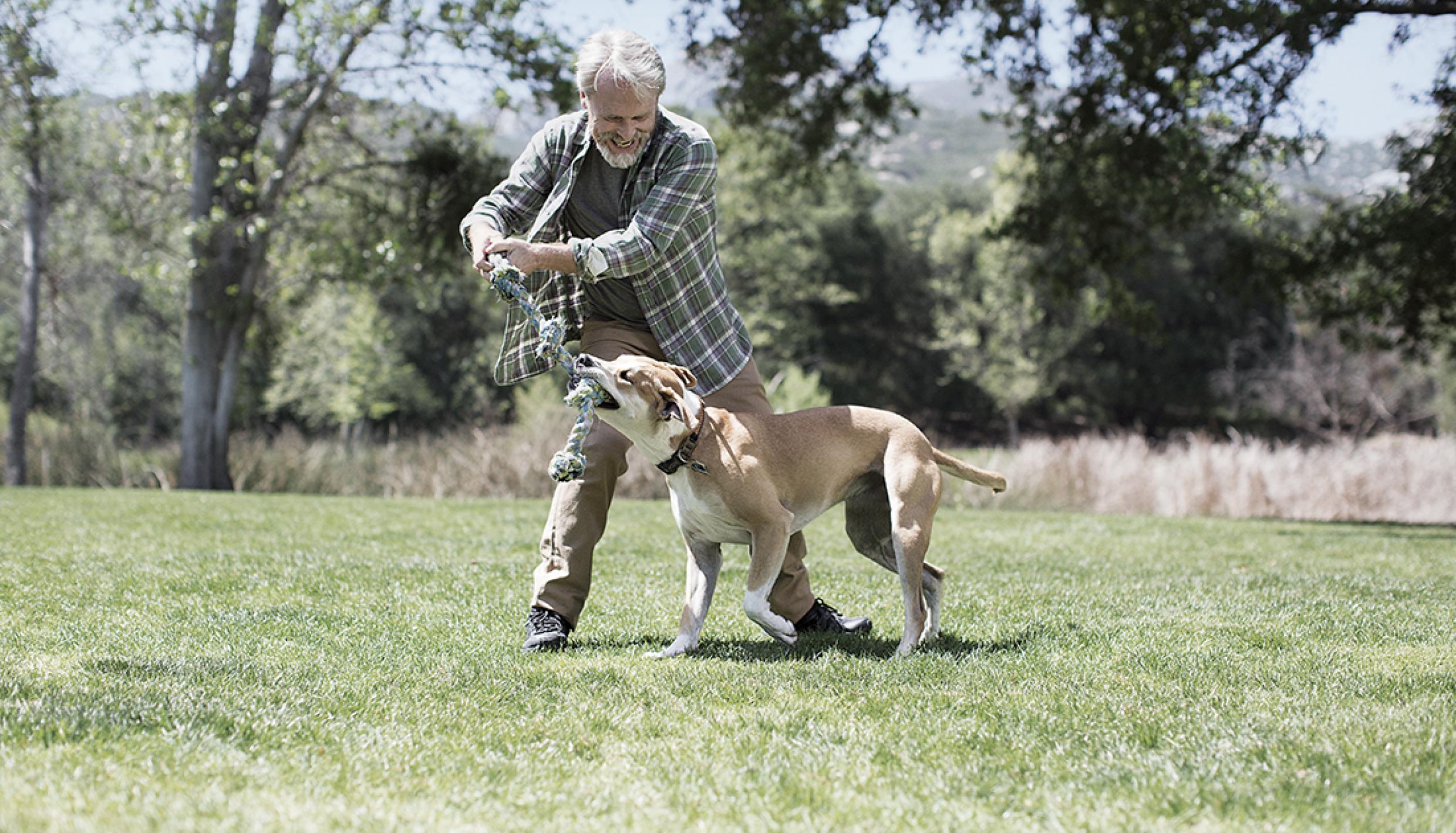  hombre jugando con perro afuera