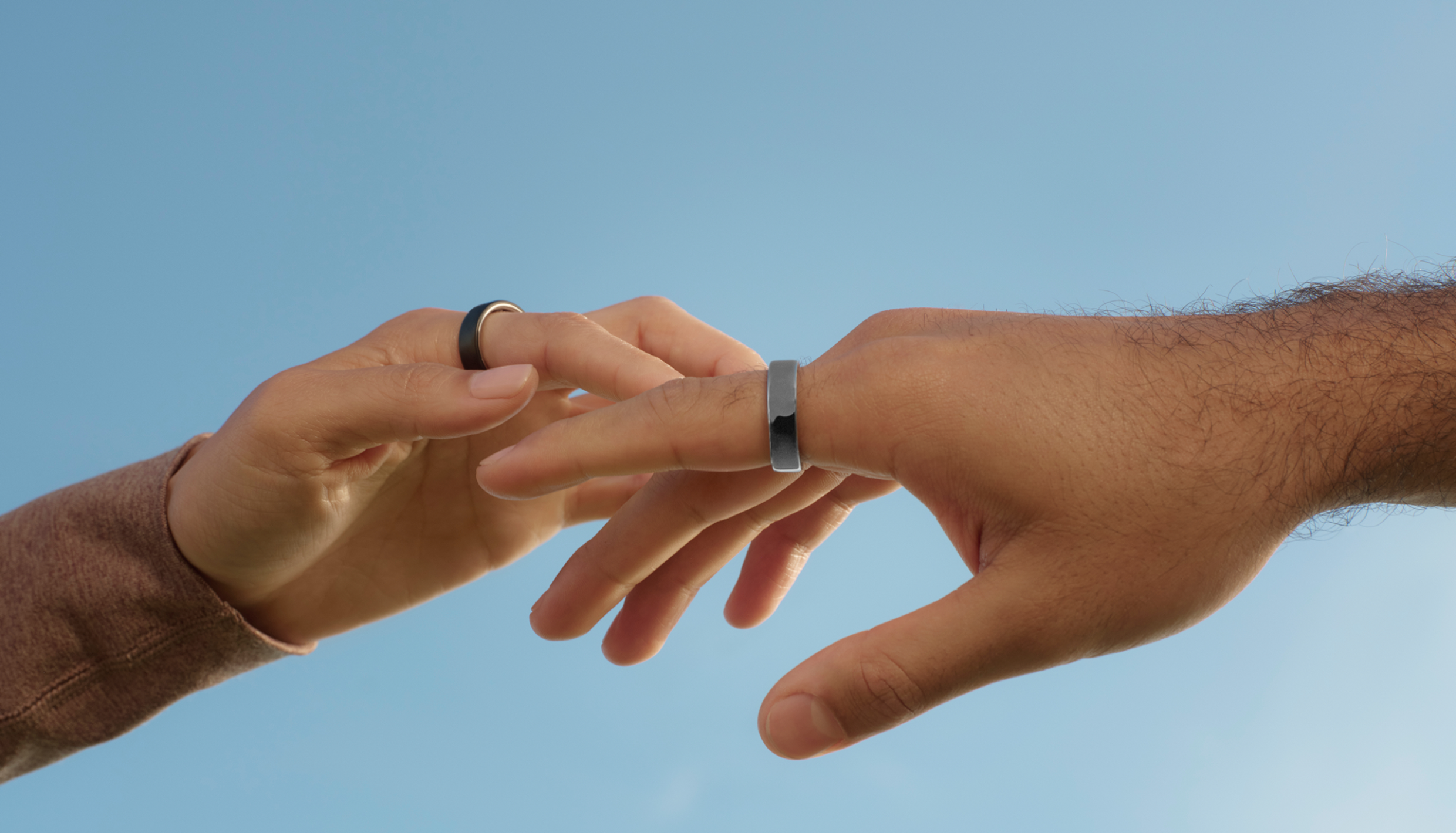 Hands touch each other wearing rings.
