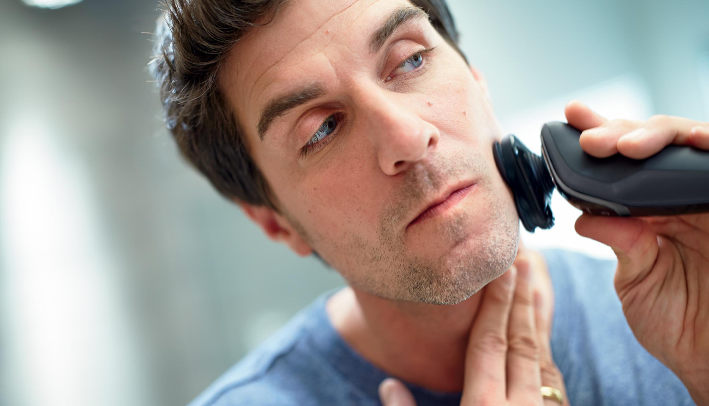 Man shaving with electric razor