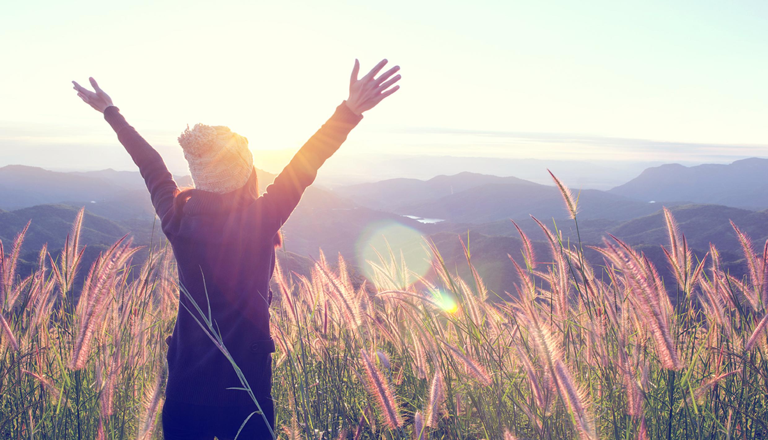 Woman opening arms on an open field