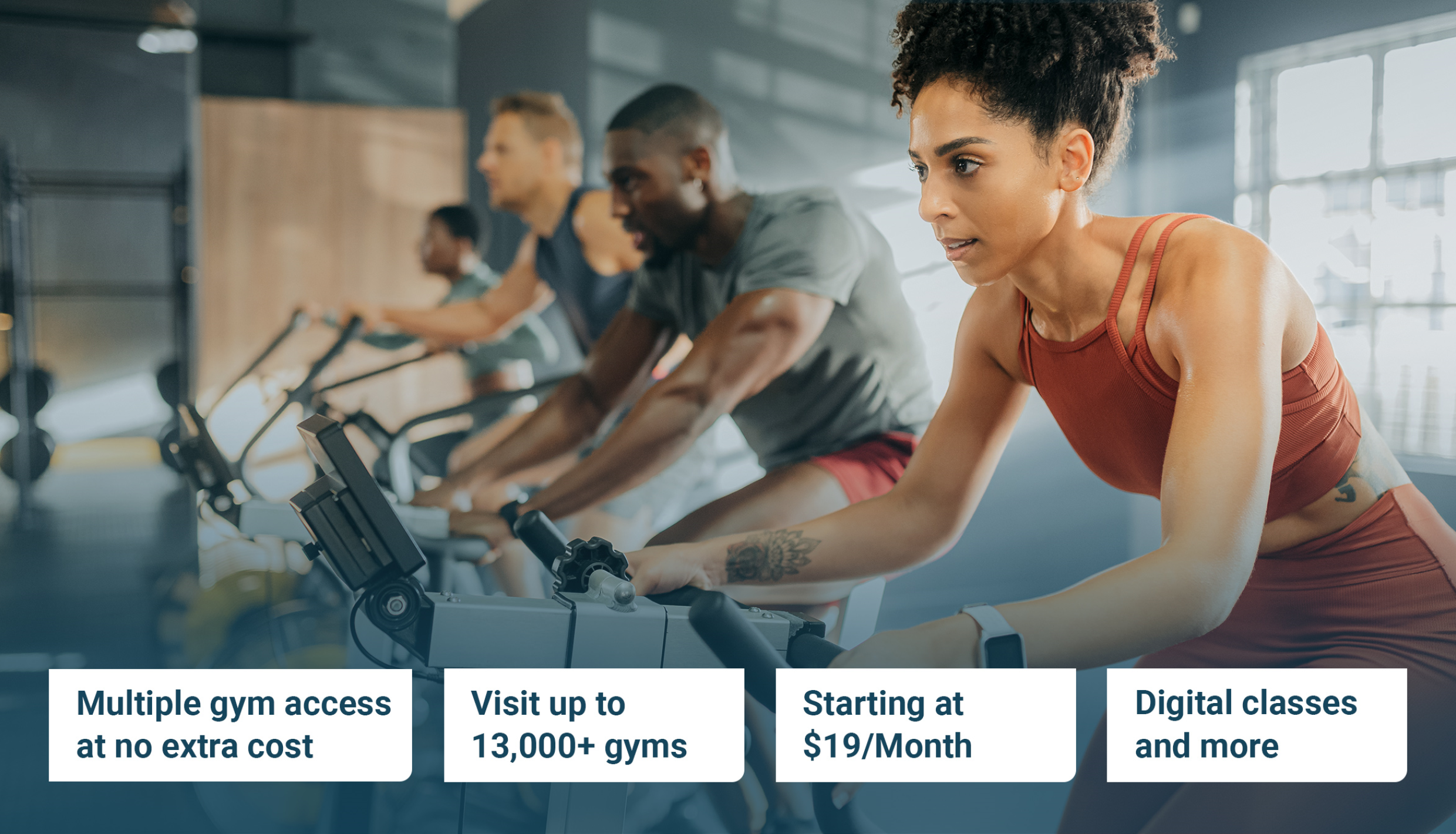 Four people in gym on spin bikes