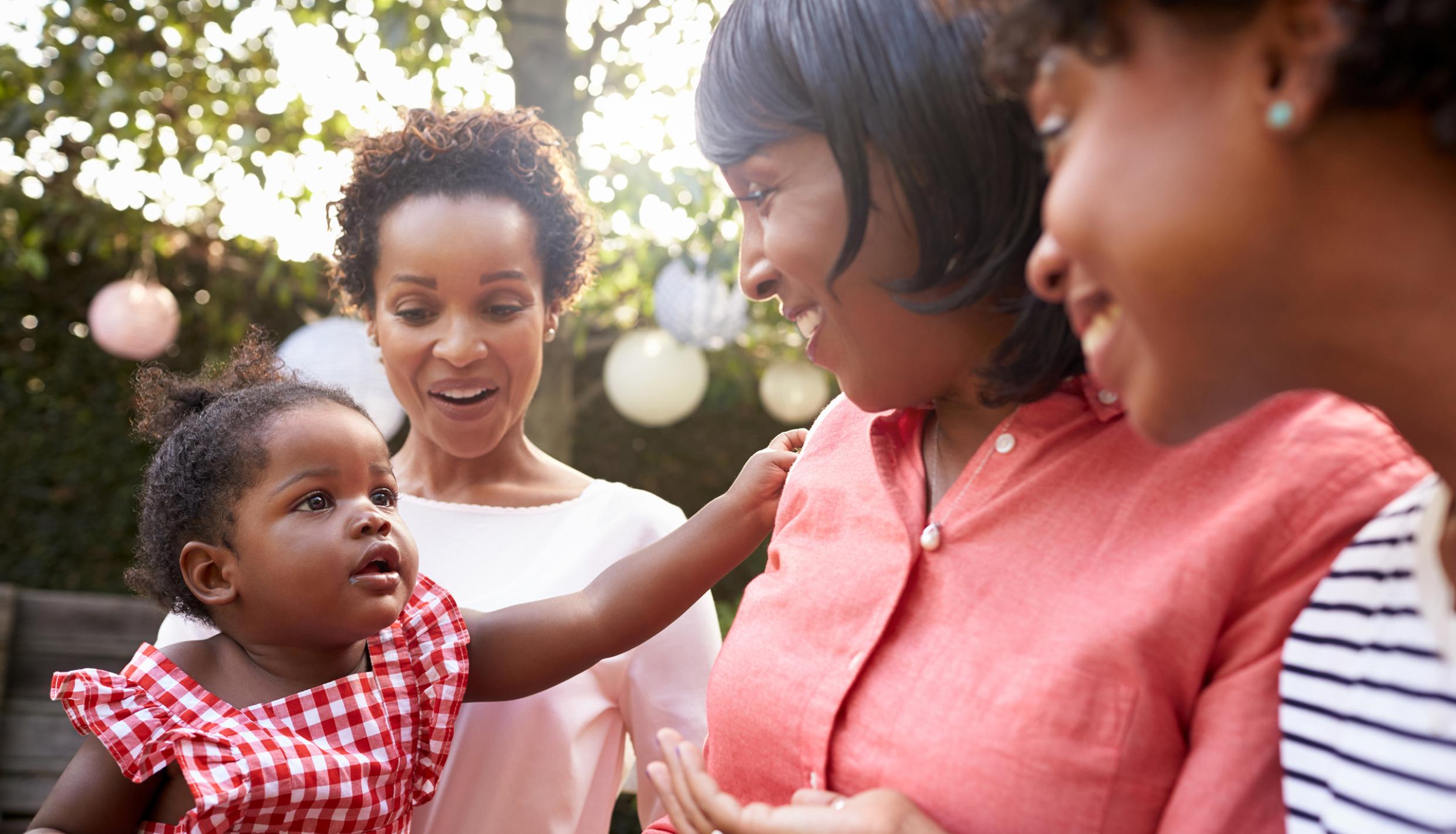 Three women standing outside with a baby