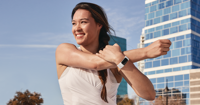 woman stretching with buildings in background