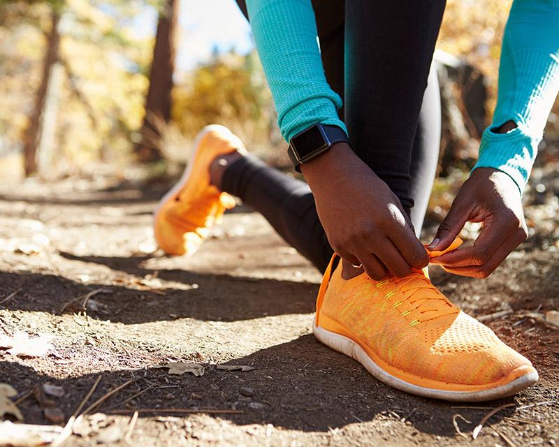 Man tying his orange running shoes