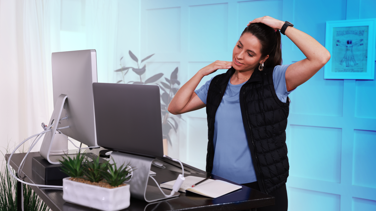 Mujer estirando el cuello delante de una Computadora portátil