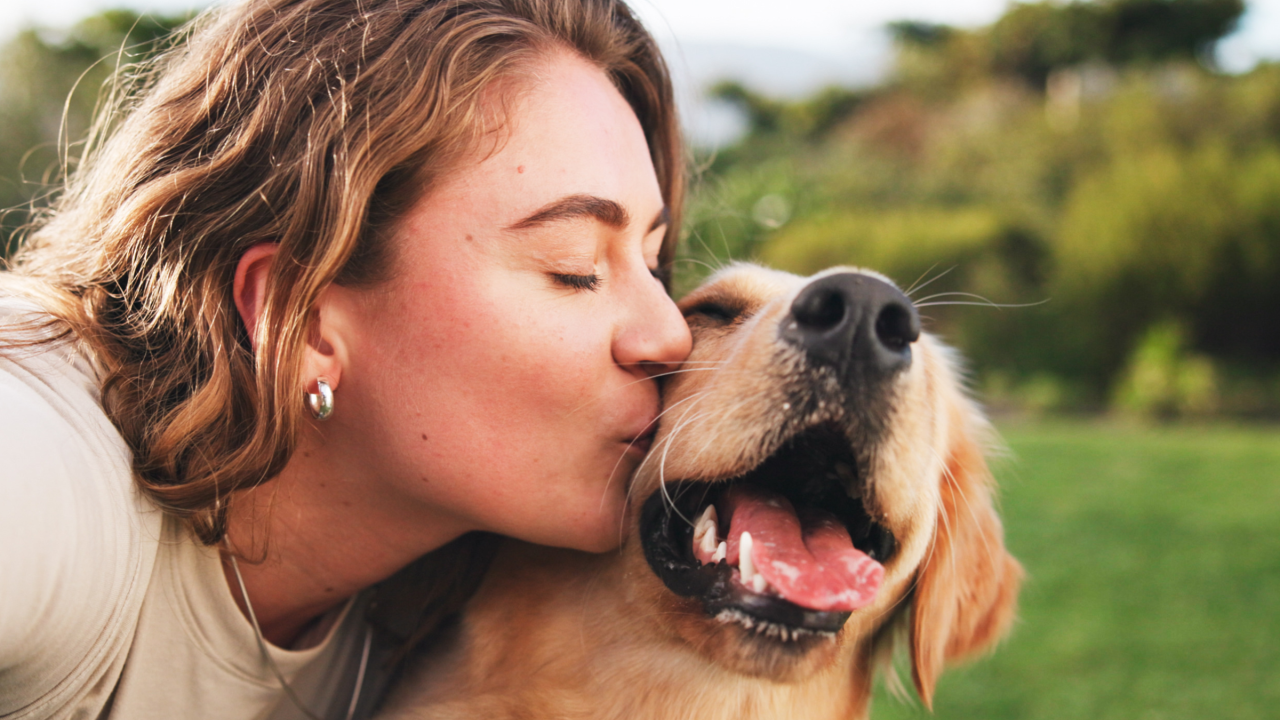 Mujer besando a un perro
