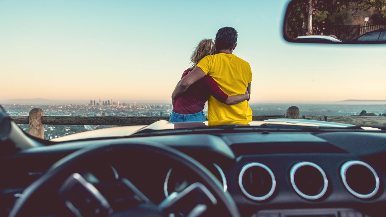 Man and woman on hood of car