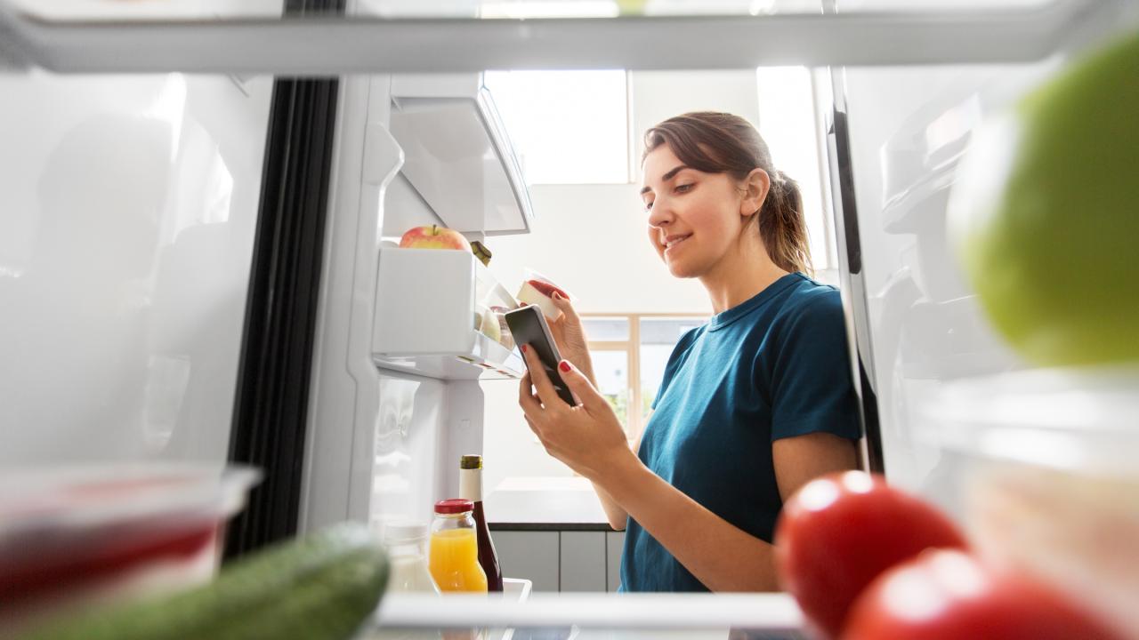Mujer mirando dentro del refrigerador