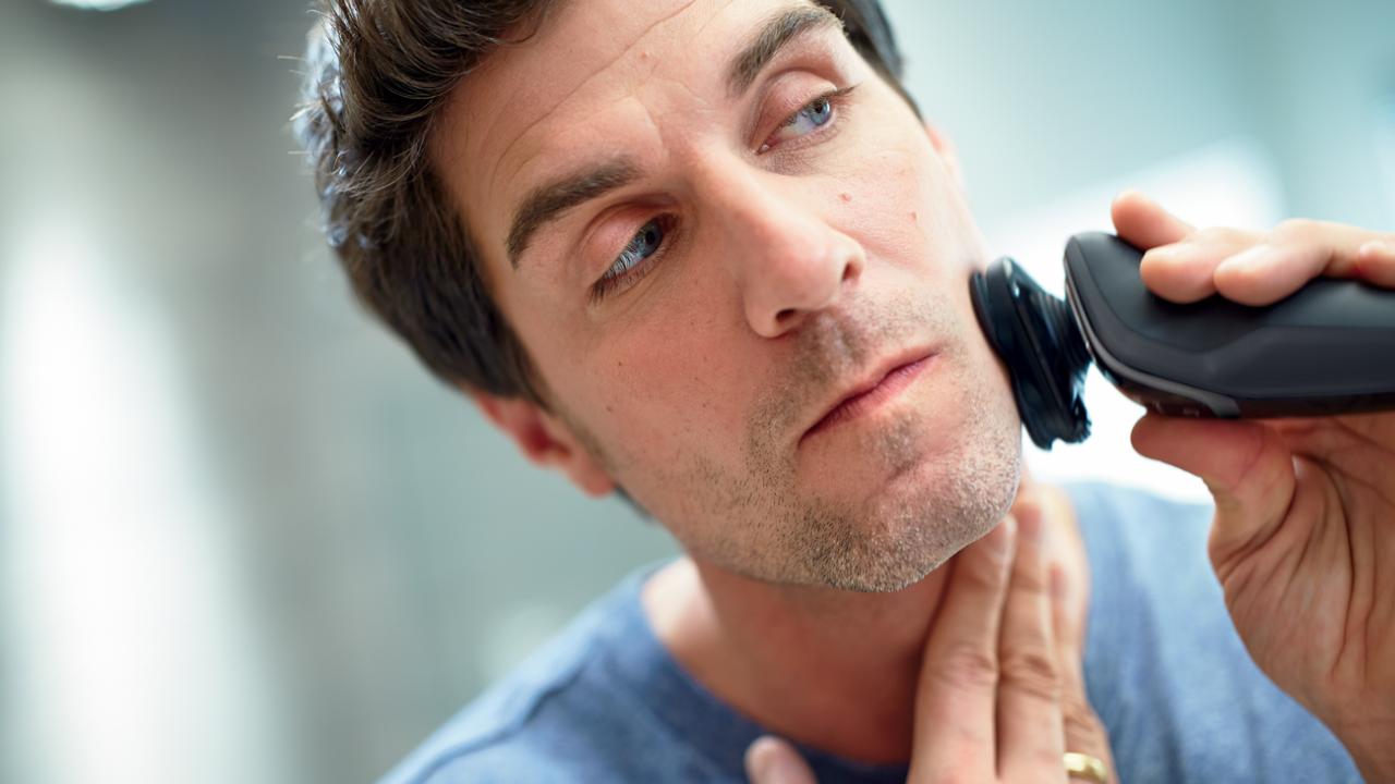 Man shaving with electric razor