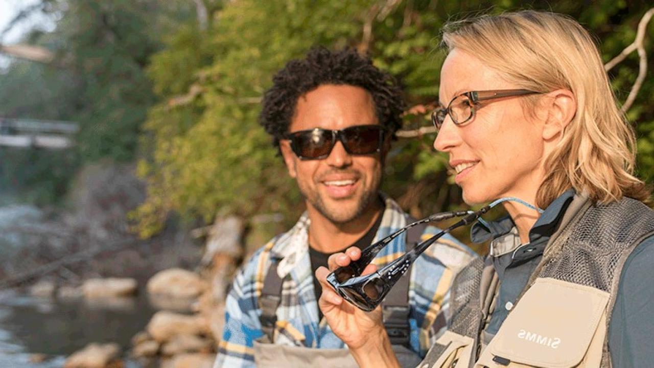 People looking over a river with hiking gear on