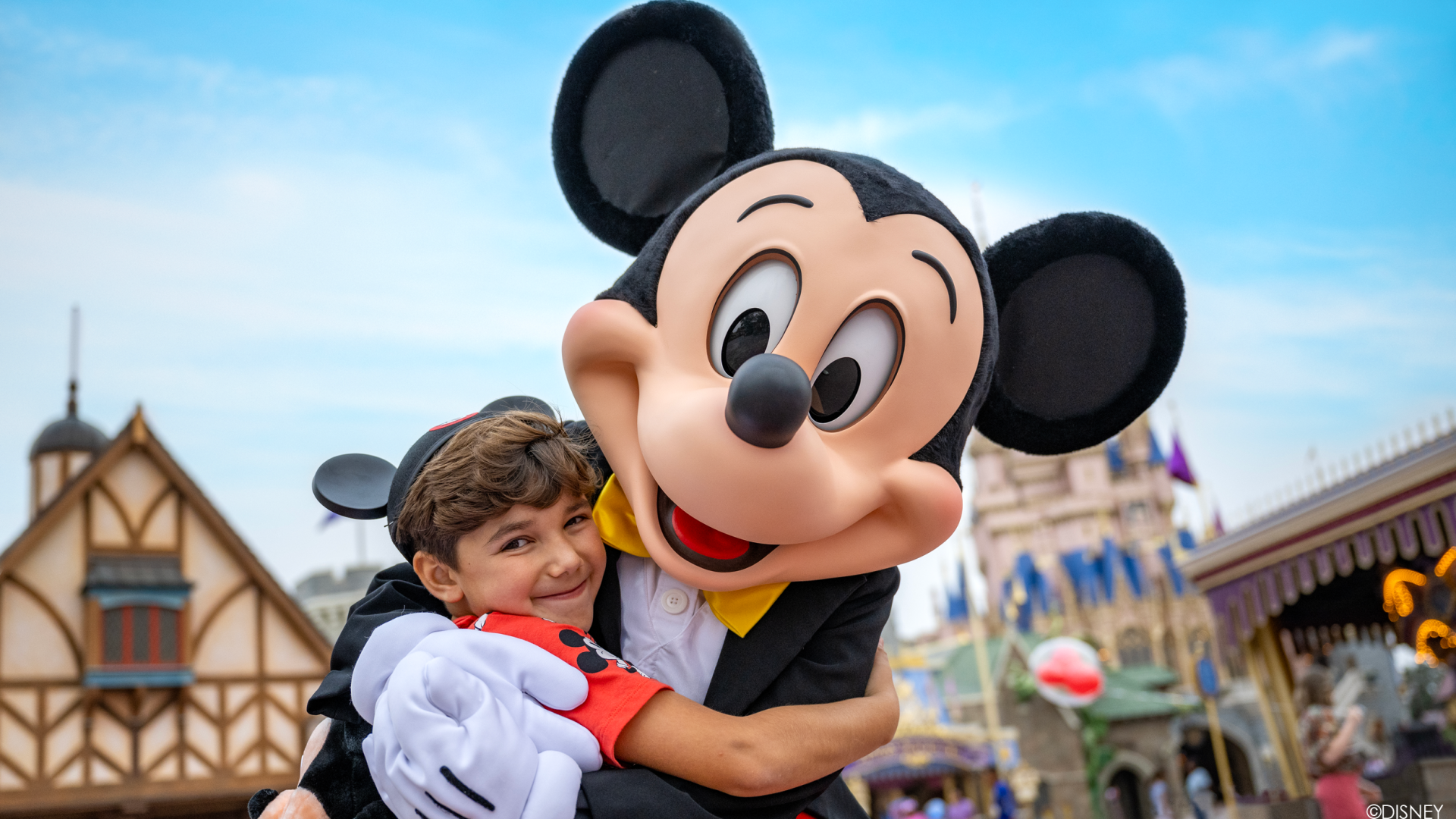 Niño abrazando a Mickey Mouse