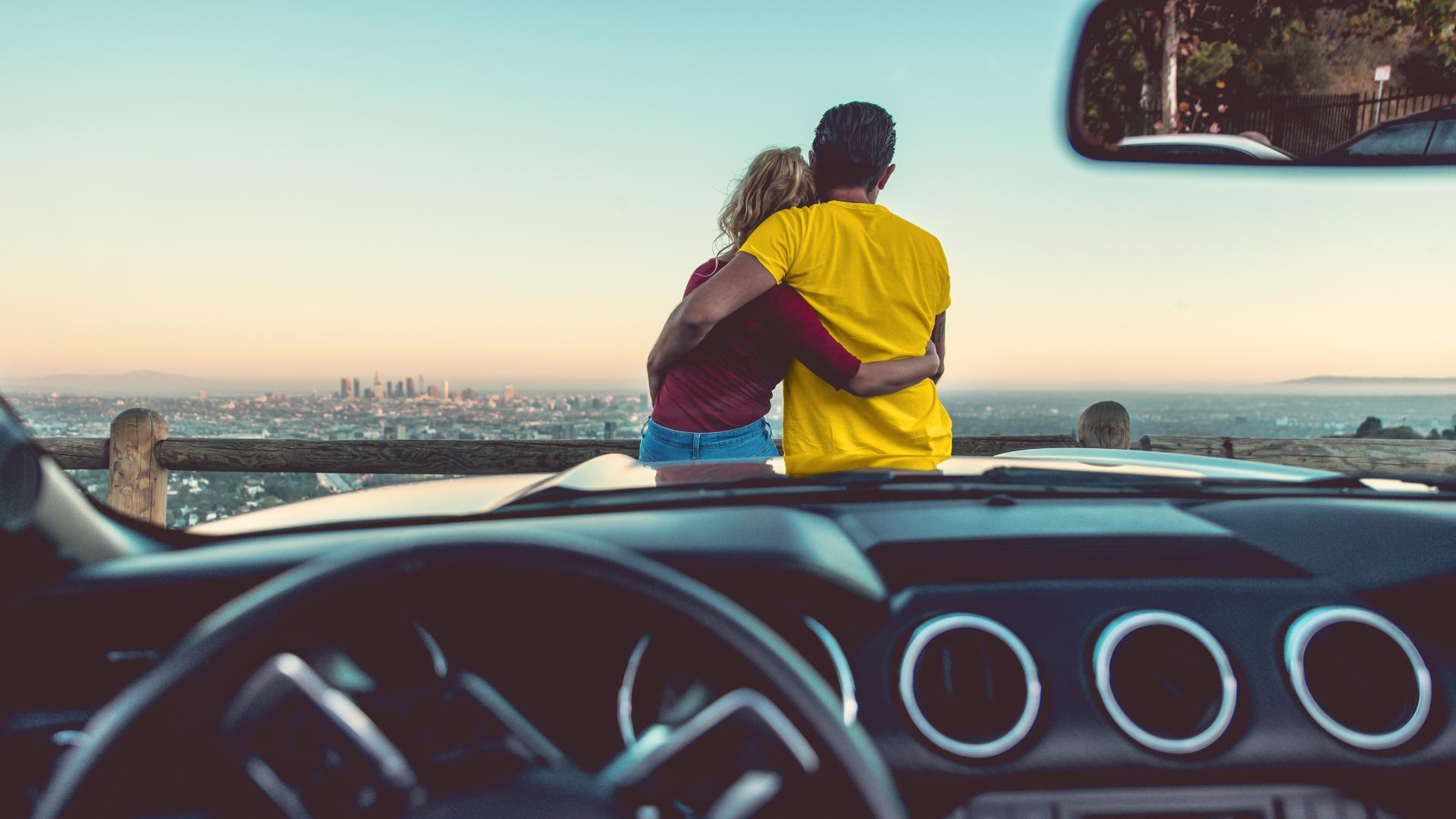 Man and woman on hood of car