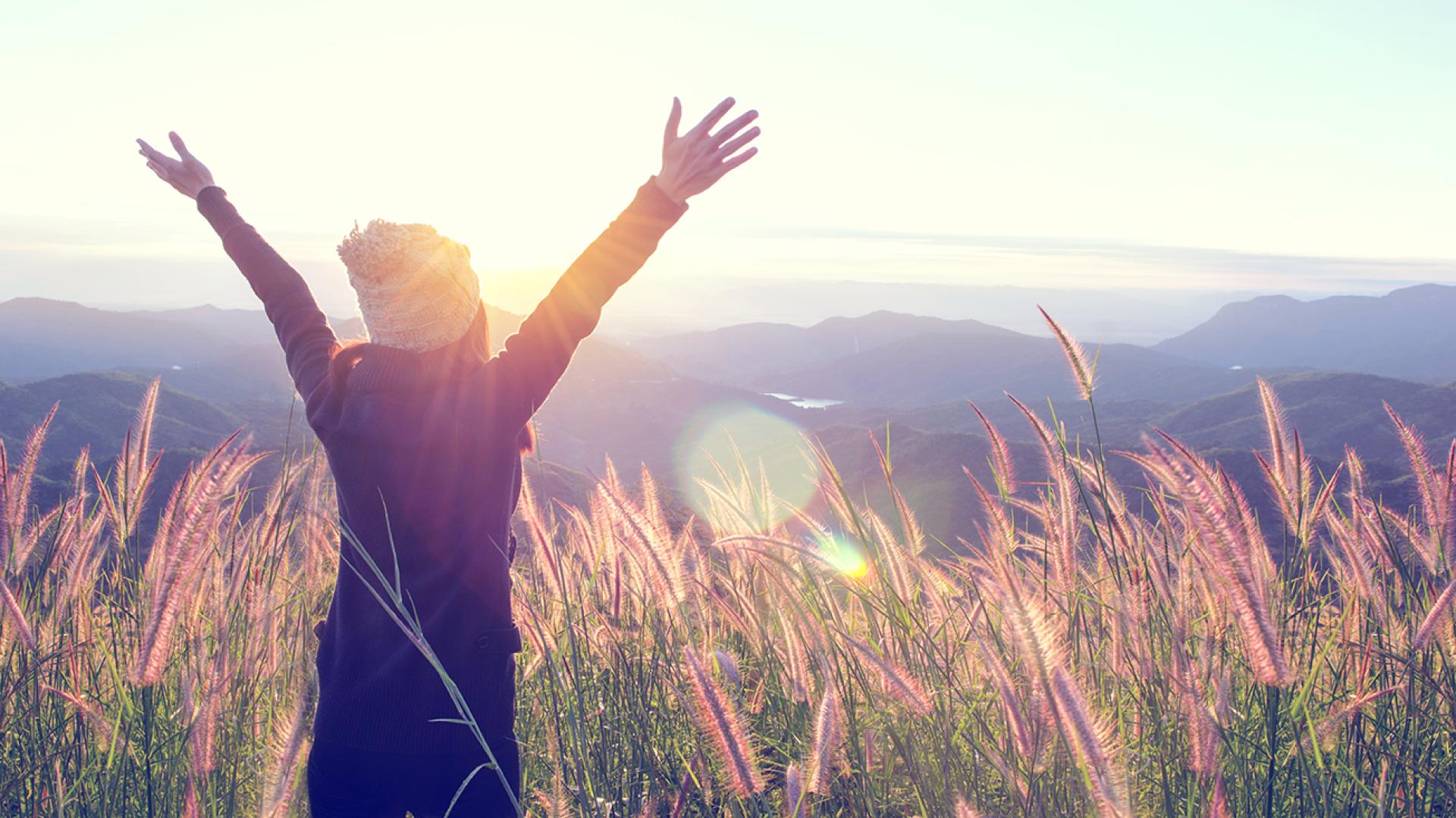 Woman opening arms on an open field