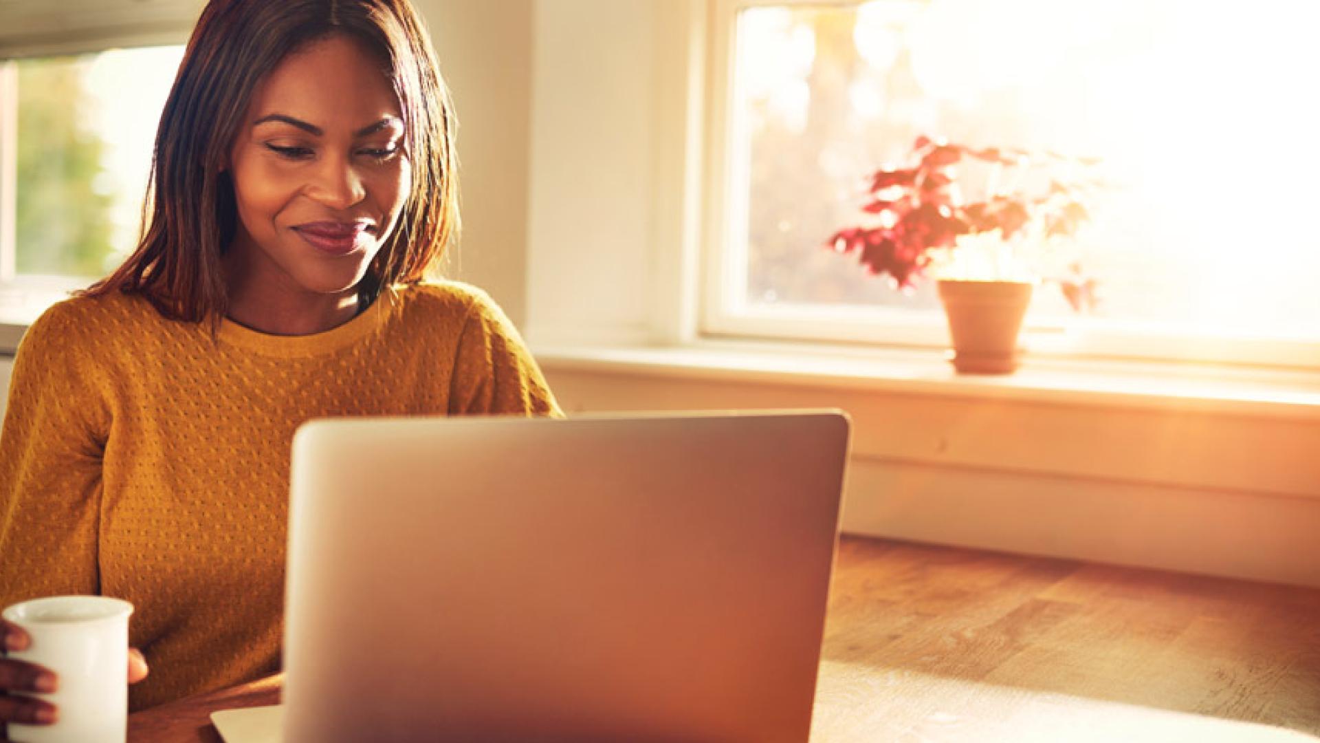 Woman at laptop in the early morning light