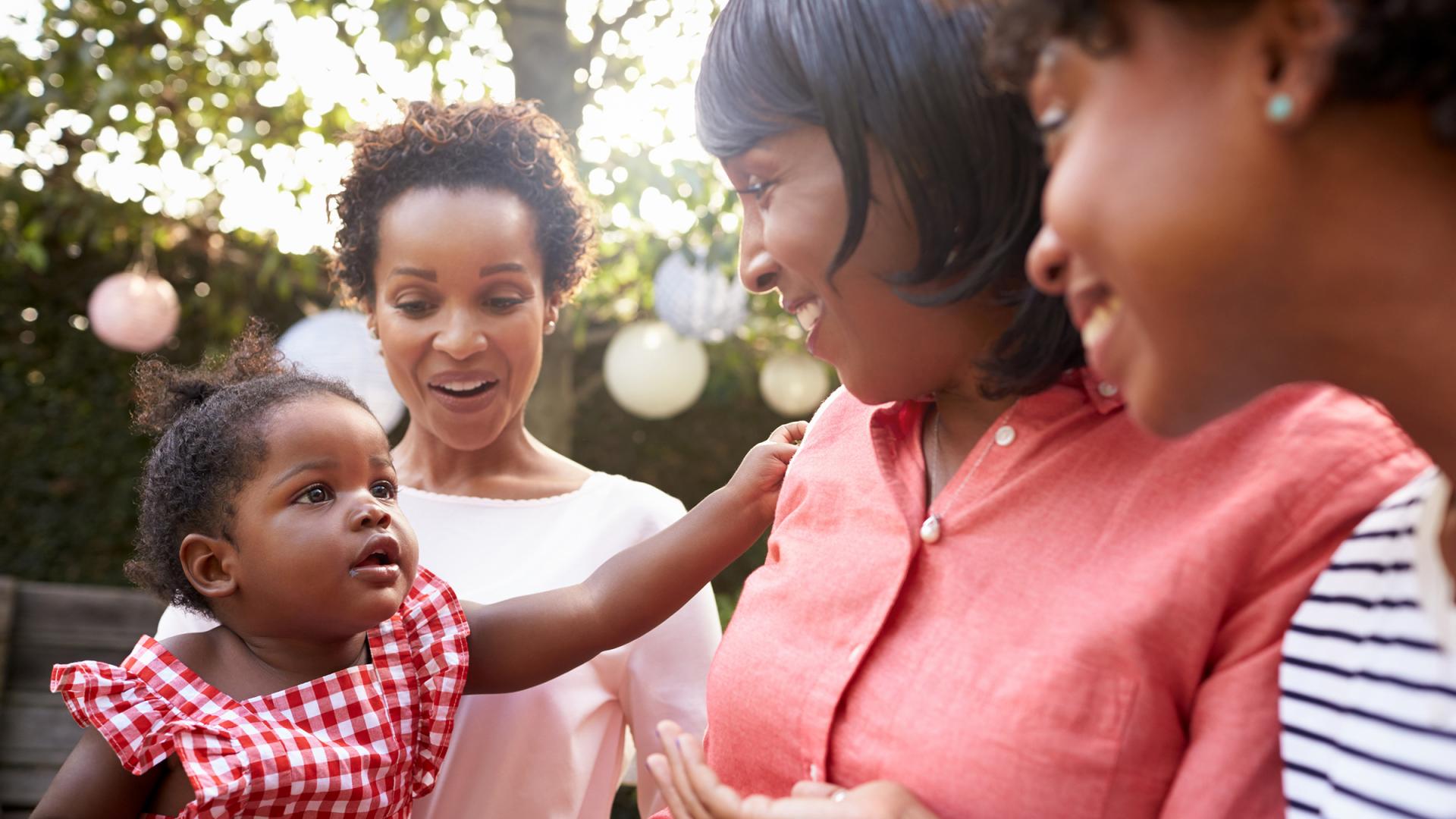 Three women standing outside with a baby