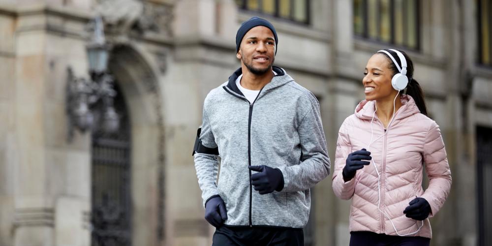 Una pareja camina enérgicamente en ropa de invierno