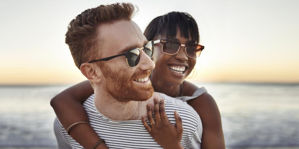 Pareja en la playa con gafas de sol