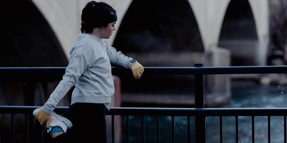 mujer estirándose y mirando el reloj