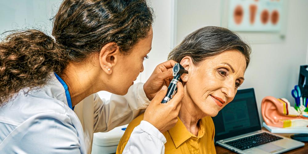 Doctora mirando el oído de una paciente