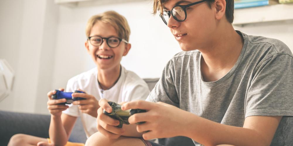 niños con espejuelos jugando video juegos