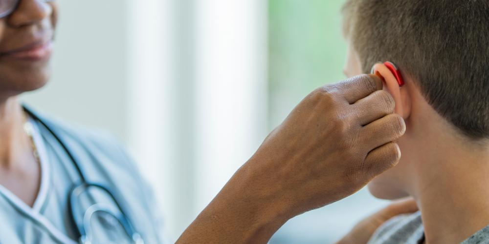 Mujer probando audífonos con joven