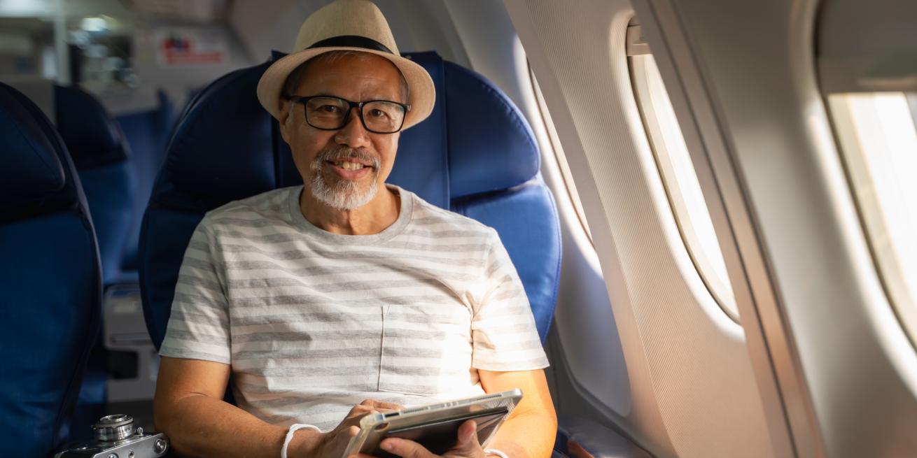hombre sentado en un avion sonriendo