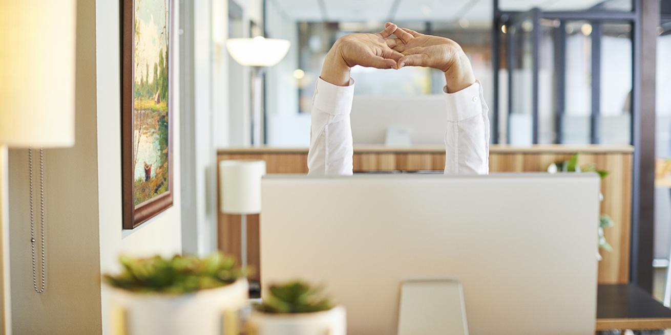 Person stretching at their computer