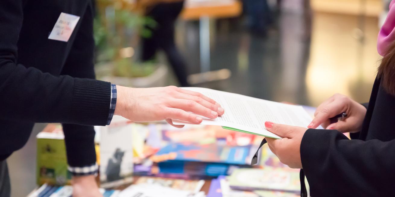 Two people holding a piece of paper