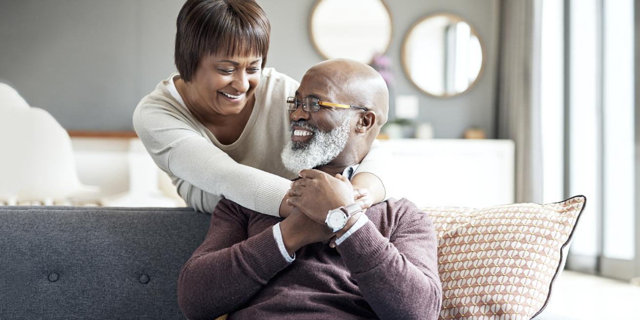 elderly couple embracing on a couch