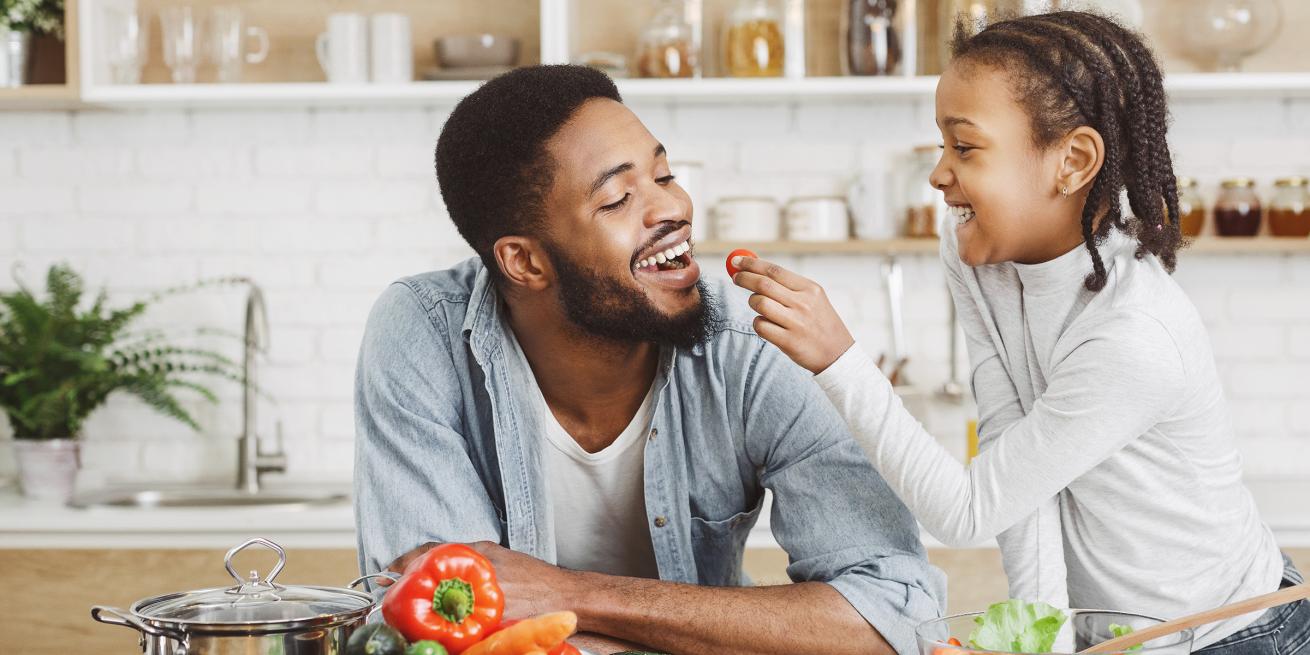 daughter feeding vegetables to father