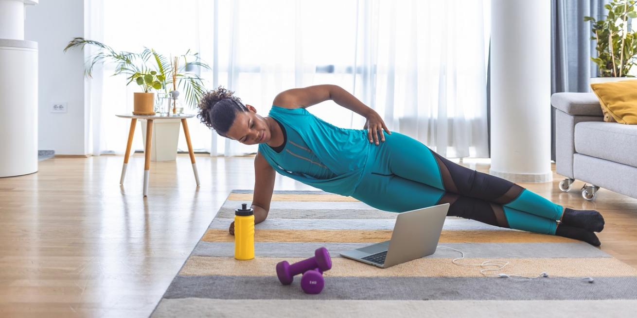 woman doing a virtual fitness class at home