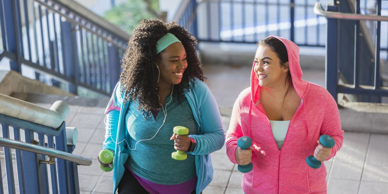 mujeres caminando sosteniendo mancuernas