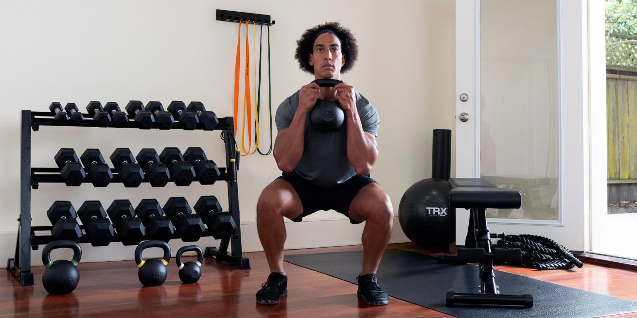 man lifting kettlebells