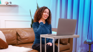 Woman stretching neck in front of laptop