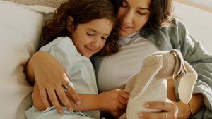 Madre e hija sentadas juntas mirando un animal de peluche